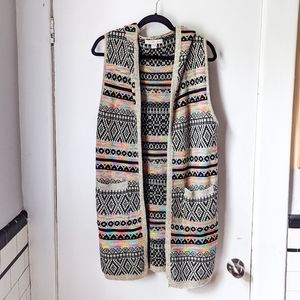 Long sleeveless knit cardigan with hood, black white and neon rainbow geometric
